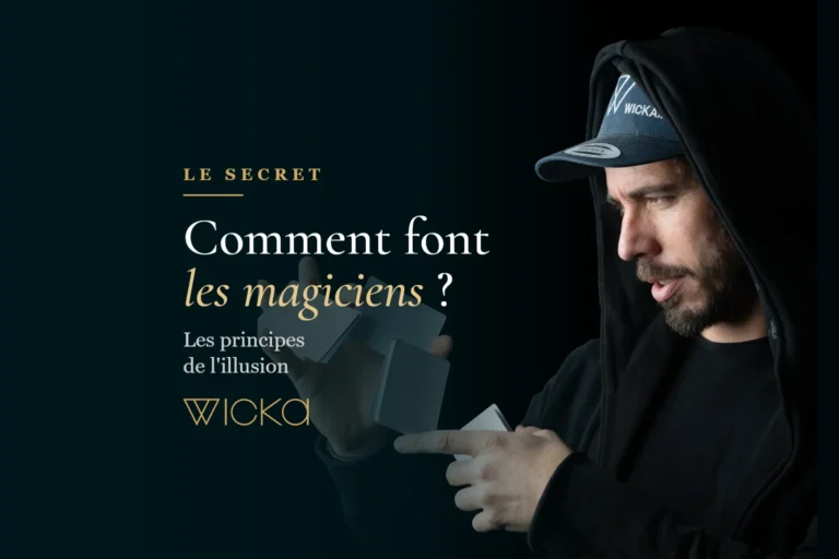 Wicka, capuche sur la tête, manipule des cartes dans la pénombre