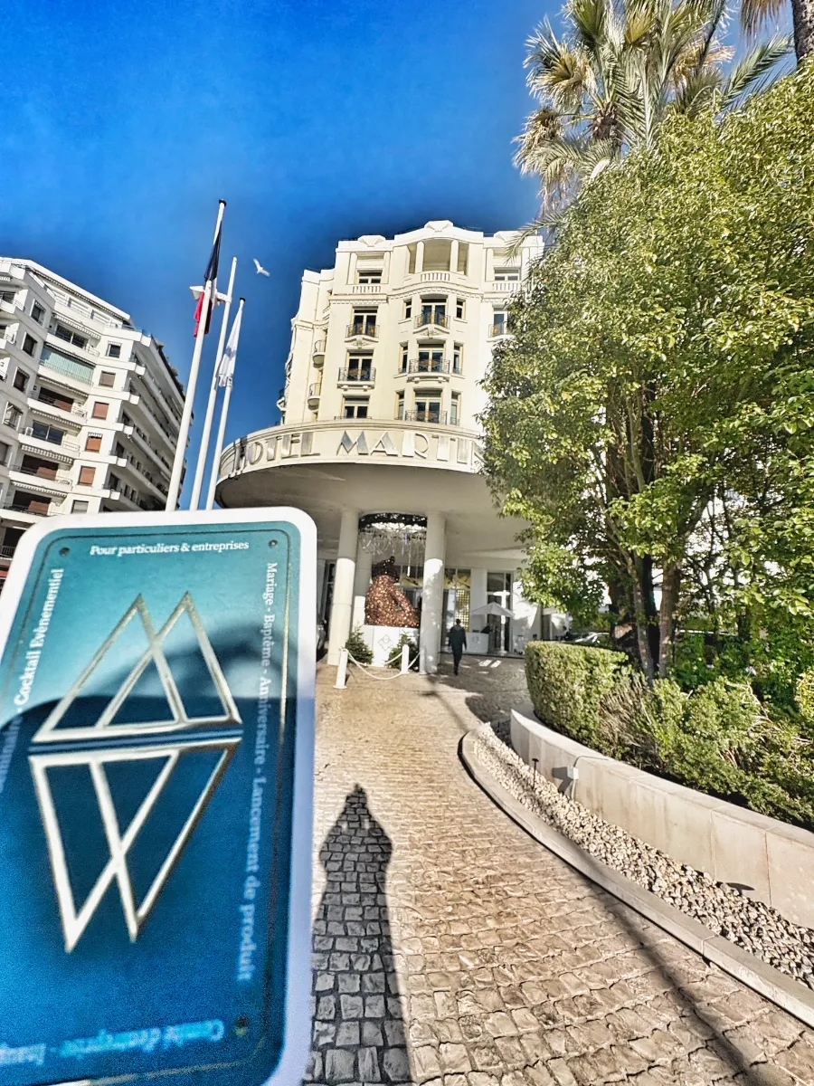 Carte de Wicka, magicien pour particuliers et entreprises, devant la façade de l'hôtel Martinez à Cannes